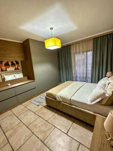 1 dormitorio con 1 cama grande y luz amarilla en Amos City Center Apartment Tirana, en Tirana