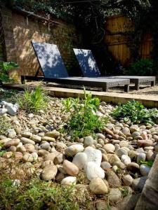 um jardim de pedra com um banco em A Seafood and Walking Enthusiasts Quiet Escape. em West Mersea