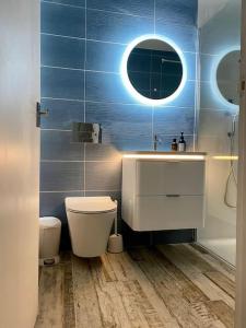 uma casa de banho com um lavatório, um WC e um espelho. em A Seafood and Walking Enthusiasts Quiet Escape. em West Mersea
