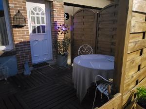 un patio con una mesa y una puerta azul en Chez Didier et vero, en Houville-la-Branche