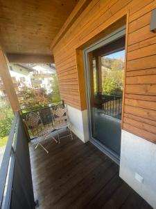 Un balcón con puerta corredera de cristal y sillas. en Appartement Pletzer, en Kitzbühel