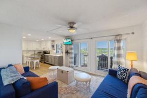 a living room with a blue couch and a kitchen at Pinnacle Port 304A in Panama City