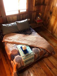 Cama pequeña en habitación con suelo de madera en RANA DE CRISTAL, en Mindo