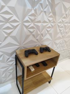 a table with two video game controllers on it at Apartamento Inteligente in Japaratinga