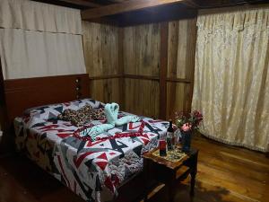 un dormitorio con una cama con un animal de peluche en RANA DE CRISTAL, en Mindo