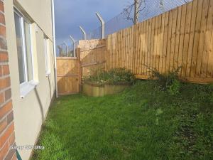 a backyard with a wooden fence and some plants at A Home From Home 3 in Plymouth