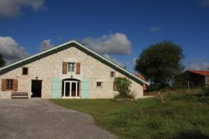 ein weißes Backsteinhaus mit grünem Dach in der Unterkunft La Maison des Eyres - Gîte Le Fadet in Pey