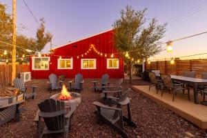 une terrasse avec un foyer extérieur et une grange rouge dans l'établissement Grand Canyon - Old West Home - Firepit - Sleeps 12, à Valle
