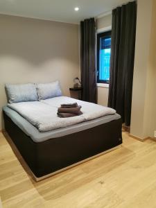 a bedroom with a bed with a black frame and a window at Svolvær city center apartment in Svolvær