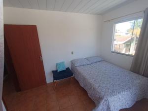 a small bedroom with a bed and a window at Casa aconchegante a 4km-5min da Guarda do Embaú in Guarda do Embaú +32 photos