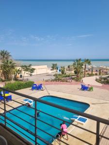 eine Person, die neben einem Pool neben dem Strand steht in der Unterkunft Casablanca Beach for families and couples only in Hurghada