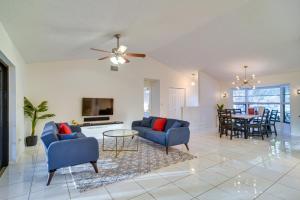 a living room with two blue chairs and a table at Sunny Palm Harbor Home with Private Pool and Hot Tub! in Palm Harbor