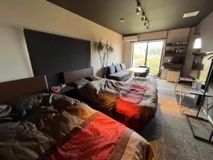 1 dormitorio con 2 camas y sala de estar en 海宿ニシノヤ 