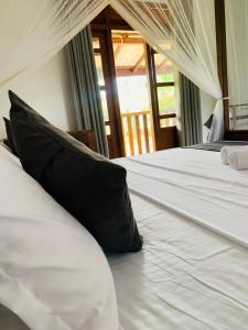 Pearl Gardens Midigama في ميديغاما إيست: سرير ابيض كبير عليه وسادة سوداء