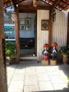 Deux statues de personnes avec des champignons sur une terrasse couverte dans l'établissement Hotel Pousada Casuarinas, à Récife