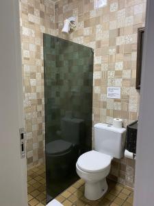 a bathroom with a toilet and a shower at Hotel Pousada Casuarinas in Recife
