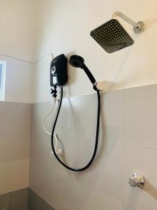 Pearl Gardens Midigama في ميديغاما إيست: دش في حمام مع هاتف على الحائط