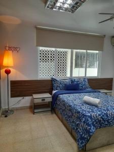 a bedroom with a bed and a lamp and windows at R-8 Amplio apartamento en zona turística. in Panama City