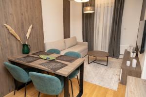 ein Wohnzimmer mit einem Tisch, Stühlen und einem Sofa in der Unterkunft FORESTA Apartment Jahorina in Jahorina