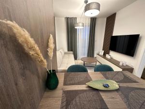 ein Wohnzimmer mit einem Esstisch und ein Wohnzimmer mit einem TV in der Unterkunft FORESTA Apartment Jahorina in Jahorina