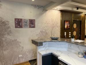 a kitchen with a counter and a wall with paintings at The Royal Apartment at New Cairo in Cairo +38 photos