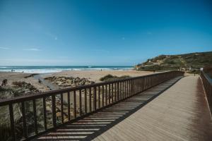 a boardwalk leading to a beach with the ocean at Aloha Surf House in Ericeira