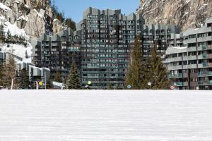 a large building with trees in the snow at Val d'Isère - Pied des pistes 4 pers in La Daille