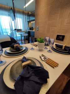 a table with plates and wine glasses on it at RN Studio Premium in Maceió