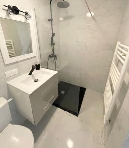 uma casa de banho branca com um lavatório e um WC em Maison du bonheur em Cagnes-sur-Mer