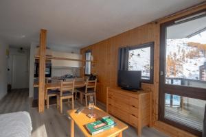 a room with a kitchen and a living room with a television at Val d'Isère - Pied des pistes 4 pers in La Daille