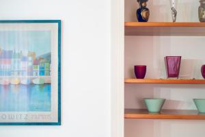 a framed picture on a shelf with vases at Al Castello di San Giusto free garage in Trieste