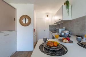 a kitchen with a table with a plate of food at Étoile de Mer * wifi * Parking * Clim * Central * in La Grande-Motte