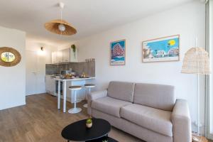 a living room with a couch and a kitchen at Étoile de Mer * wifi * Parking * Clim * Central * in La Grande-Motte
