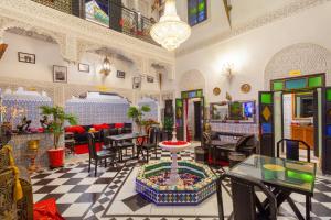a lobby with tables and chairs and a room with a table at Riad La Porte d'Or & SPA in Marrakech
