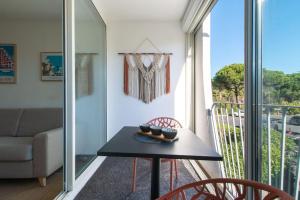 a room with a table and a couch and a balcony at Étoile de Mer * wifi * Parking * Clim * Central * in La Grande-Motte +27 photos