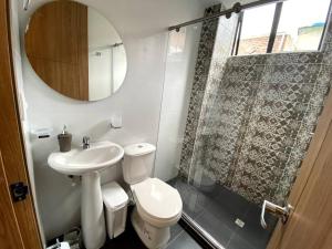 uma casa de banho com um WC, um lavatório e um espelho. em Hermoso Apartaestudio Duplex cerca a Unicentro em Pasto