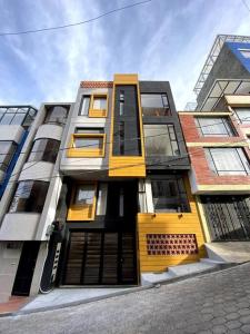 a tall building with yellow doors on a street at Hermoso Apartaestudio Duplex cerca a Unicentro in Pasto