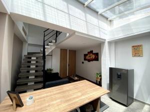 uma sala de estar com uma escada e uma mesa de madeira em Hermoso Apartaestudio Duplex cerca a Unicentro em Pasto