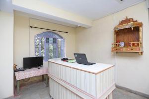 a room with a desk with a laptop on it at OYO Flagship Hotel New Urvashi in Hājīpur