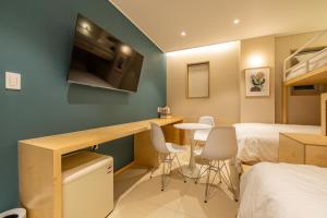 a room with a bed and a desk with a tv at Hithere City Myeongdong in Seoul