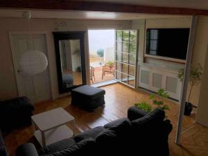 uma sala de estar com um sofá e vista para um pátio em Byhus-lejlighed med sjæl og privat gårdhave em Hurup