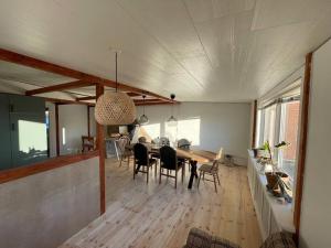 Hurup的住宿－Byhus-lejlighed med sjæl og privat gårdhave，用餐室以及带桌椅的起居室。