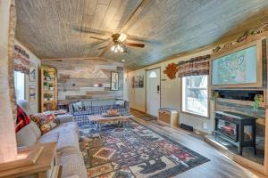 a living room with a couch and a fireplace at Northville Cabin with Fire Pit, 4 Mi to Boat Ramp! in Northville