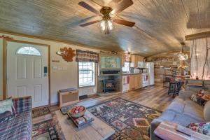 a living room with a couch and a ceiling fan at Northville Cabin with Fire Pit, 4 Mi to Boat Ramp! in Northville