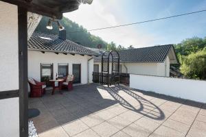 LangenthalにあるFerienapartment Am Gaulsbachのパティオ(テーブル、椅子、フェンス付)