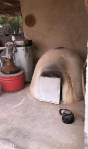 - un four en pierre avec une cuisinière et un pot dans l'établissement auberge touristique zriouila, à Guelmim