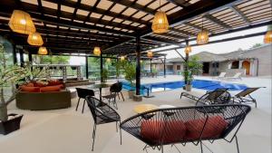 a patio with chairs and tables and a pool at Hacienda Hosteria Chorlavi in Ibarra