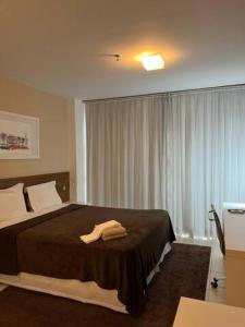 a bedroom with a bed with a towel on it at Lindo flat no Vision - centro de Brasília in Brasilia