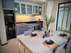 a kitchen with a table with chairs and a dining room at Horizon Vista Pool Villa Family Retreat Bangtao in Phuket