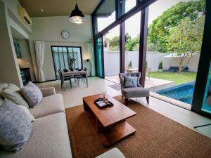 a living room with a couch and a table at Horizon Vista Pool Villa Family Retreat Bangtao in Phuket
